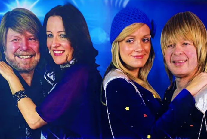 Two couples standing together with a blue light in the background.