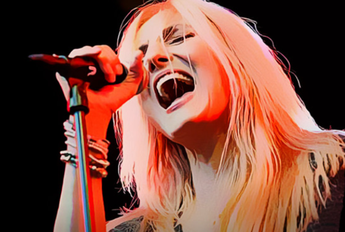Sass Jordan holding on to a microphone and singing.