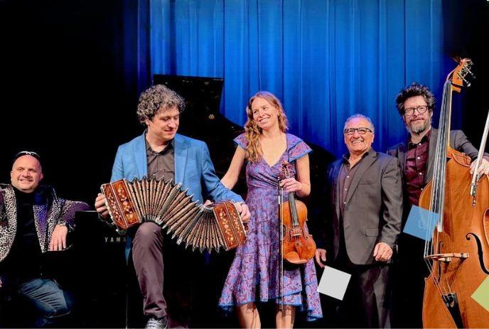 Musicians on stage with piano, bandoneon, violin, and bass, dressed formally, ready for a concert.