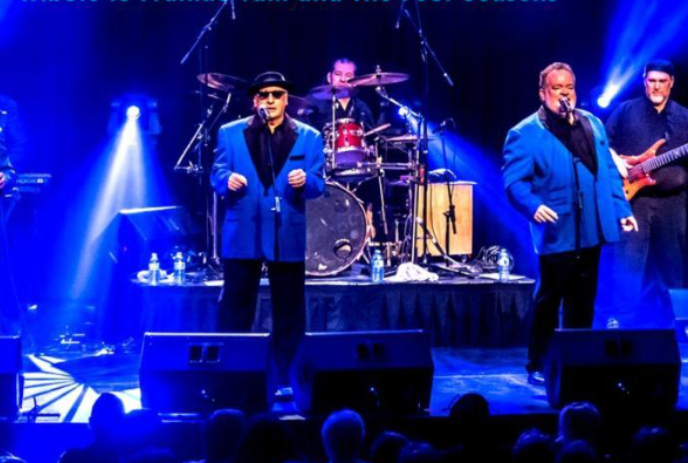 Group of men on stage dressed in blue and black and performing.