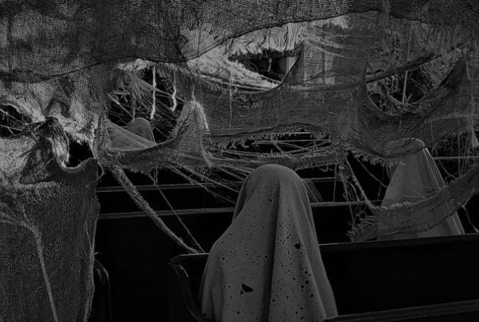 Ghostly figures in white shrouds sit in dark, abandoned chapel with hanging fabric and eerie shadows.