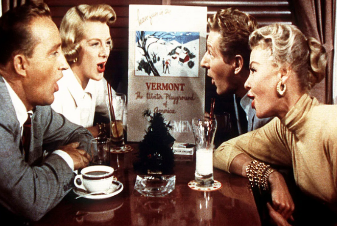 Two couples sitting at a booth in a diner singing together.