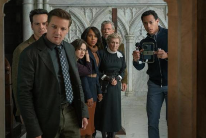 Seven people standing in a doorway looking shocked.