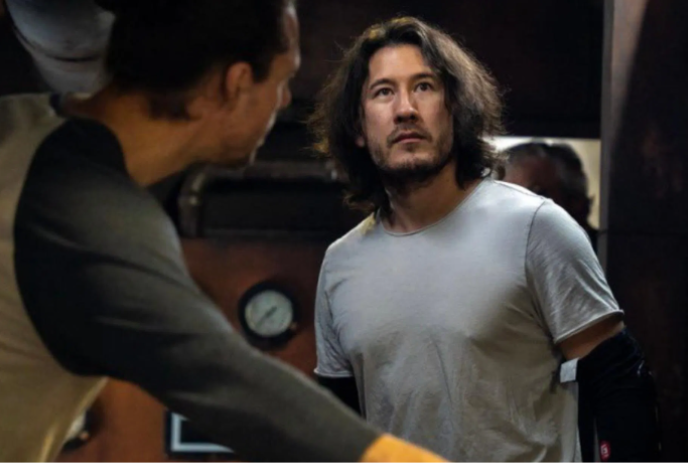 Two people standing in a room, one looking very concerned.