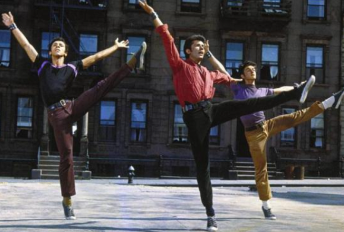 Three people in the middle of an outside square dancing.