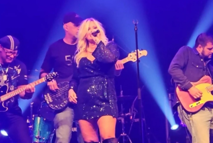 Amanda Keeles on stage singing with the band behind her.