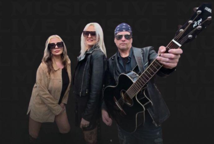 Three musicians stand together with guitar against dark backdrop promoting bold free live music vibe.