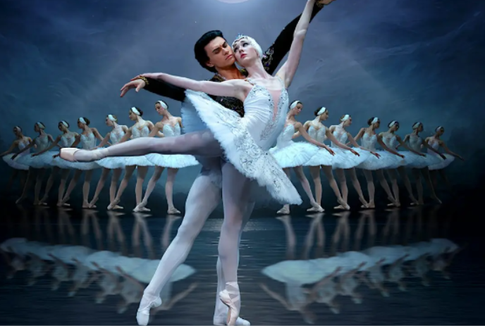 Two ballet dancers are dancing in front of a line-up of dancers.
