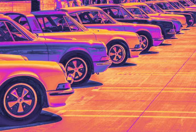 A line of Porsche cars in orange and purple hues.