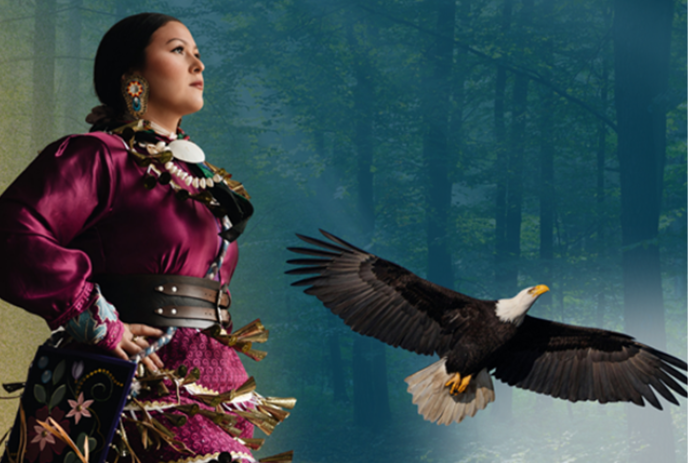 An Indigenous person in ceremonial attire dancing with an eagle flying beside them.