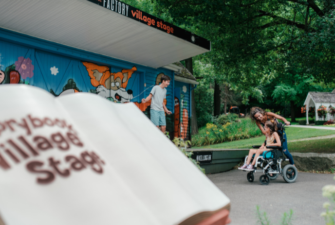 A storybook superimposed in front of three people at the stage.