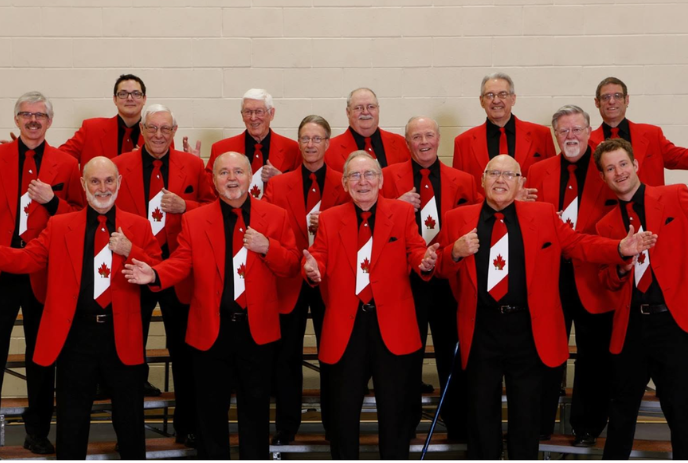 Group of men dressed in red blazers and Canada flag ties standing together.