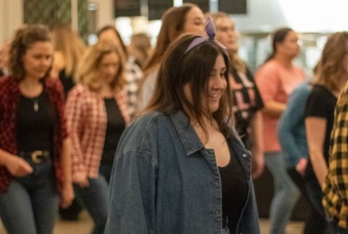 Group of people line dancing together on the dance floor.