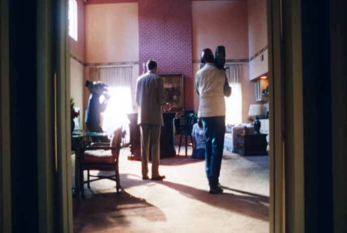 People holding cameras shooting a movie scene in a room.