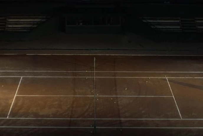 A haunting image of a desolate tennis court sitting idle .