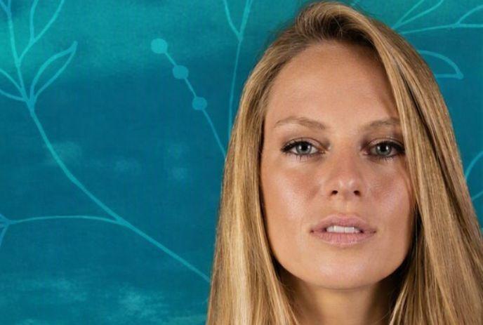 Nora en pure before teal background with leaf patterns.