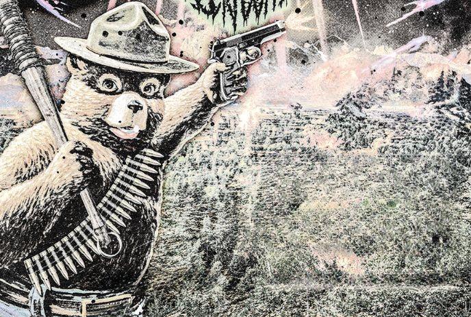 Armed bear in ranger hat holding handgun and spiked bat against textured pastel forest backdrop.