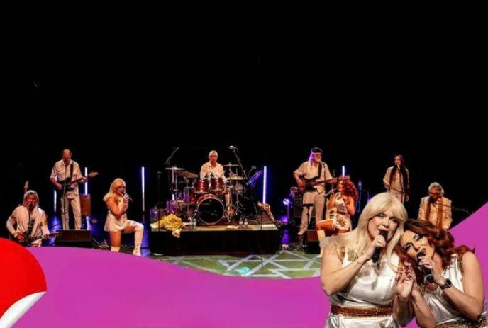 Live band performing on stage with singers, drummer, guitarists, and vibrant purple accents.