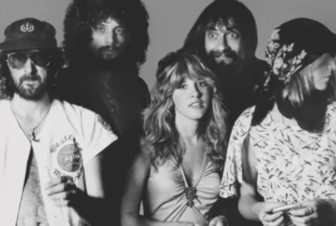 Black and white image of five band members standing together.