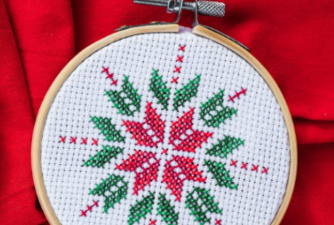 Red, white and green ornament done in cross-stitch.