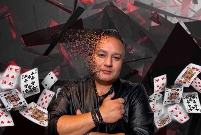 Keith O'Brien posing in a black shirt, disappearing, with playing cards around him.