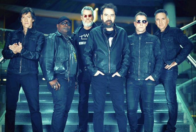 6 band members of the band Strange Advance, posing together on a dark staircase, wearing leather jackets..