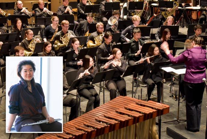 A conductor leads a large orchestra with woodwinds, brass, and percussion.