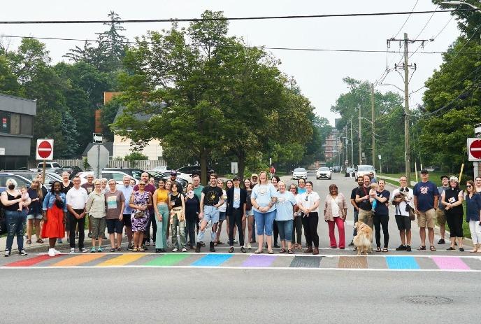 People standing on a colourful crosswalk in Wortley Village, London, Ontario.