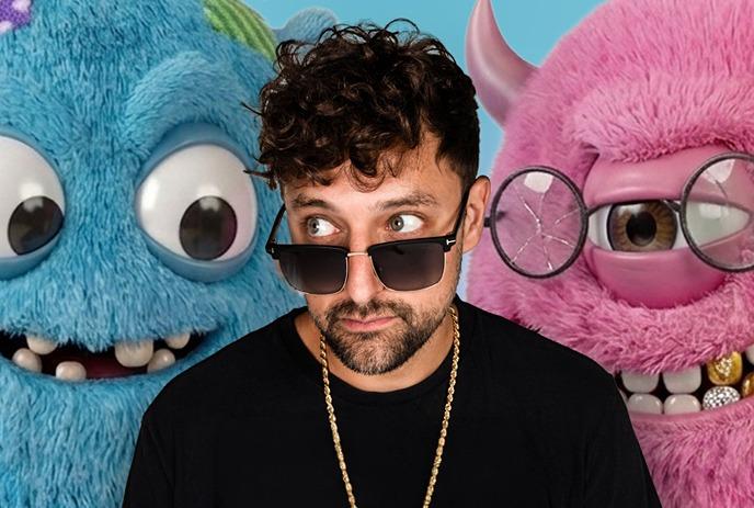 Artist in black shirt and sunglasses stands between blue and pink fuzzy cartoon monsters smiling.