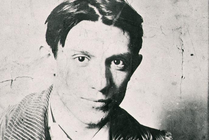 Picasso in a black and white portrait, facing the camera with a calm, neutral expression.