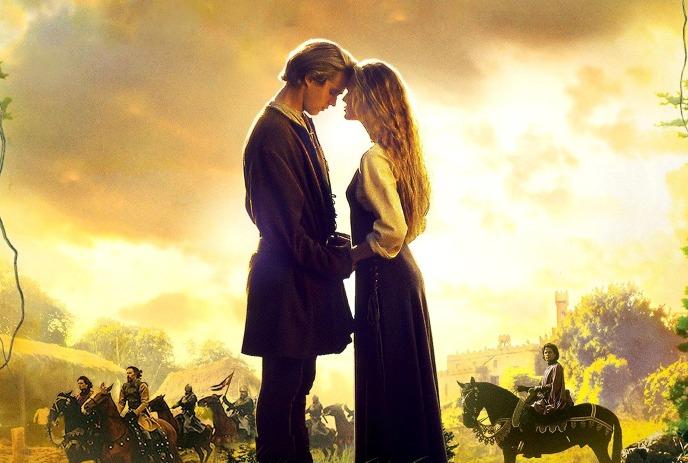 A couple stands near majestic knights on horseback as a castle looms behind them, set in a warm golden sky.