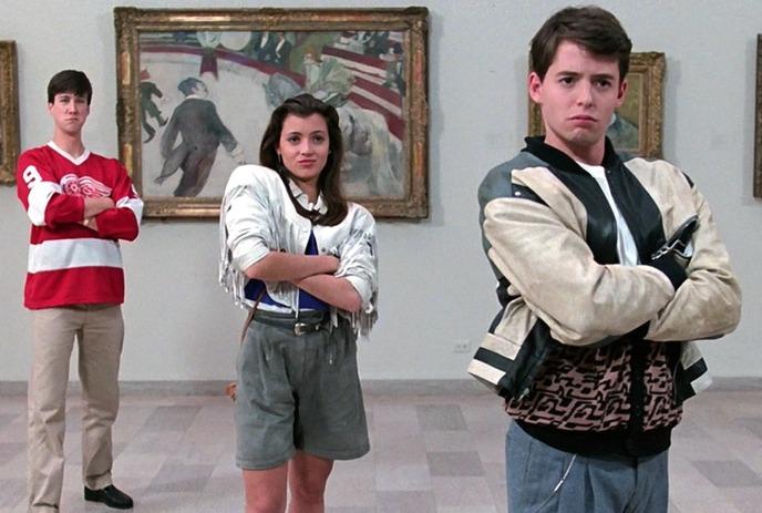 Three people standing in art gallery arms crossed before framed paintings wearing varied outfits confidently.