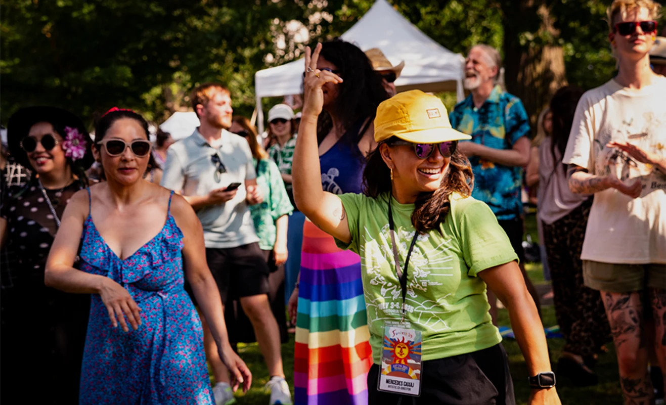 people standing and dancing in a park