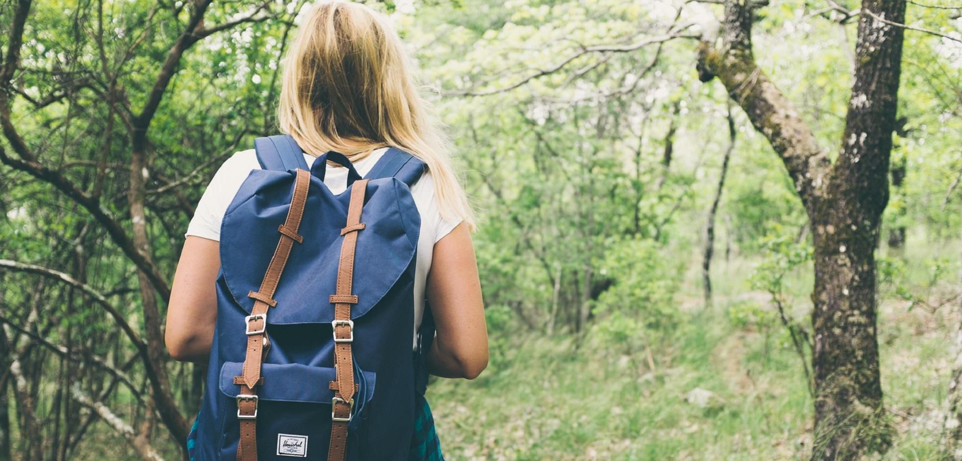 A girl with a blue backpack hiking through a trail in Kilally Meadows.