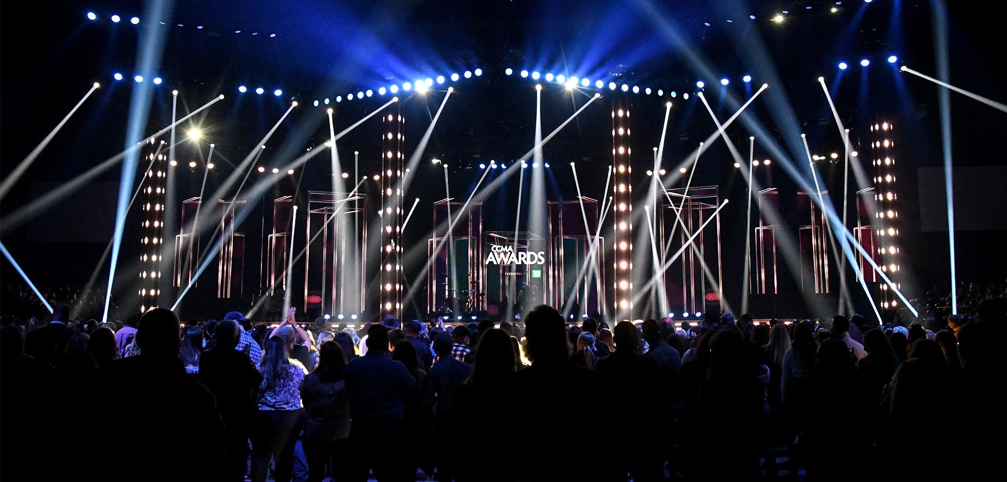 big stage with lights in the background and audience in the shadows