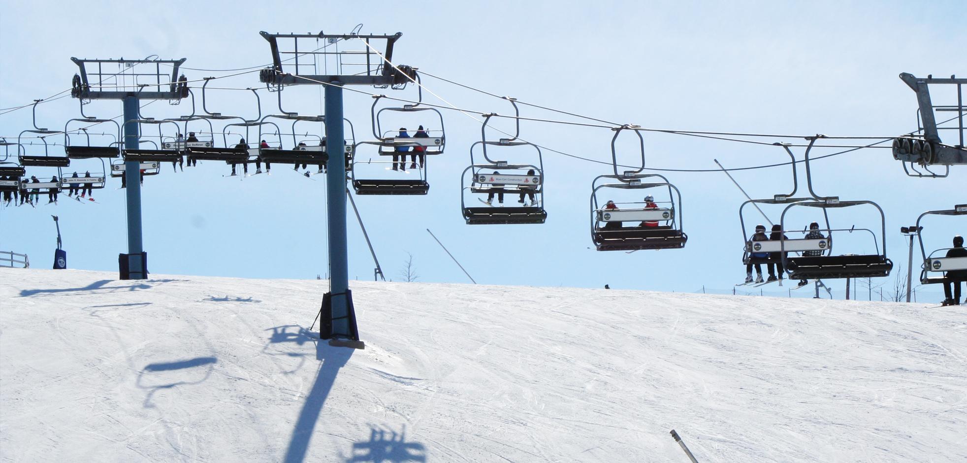 A ski lift on a snow sunny day