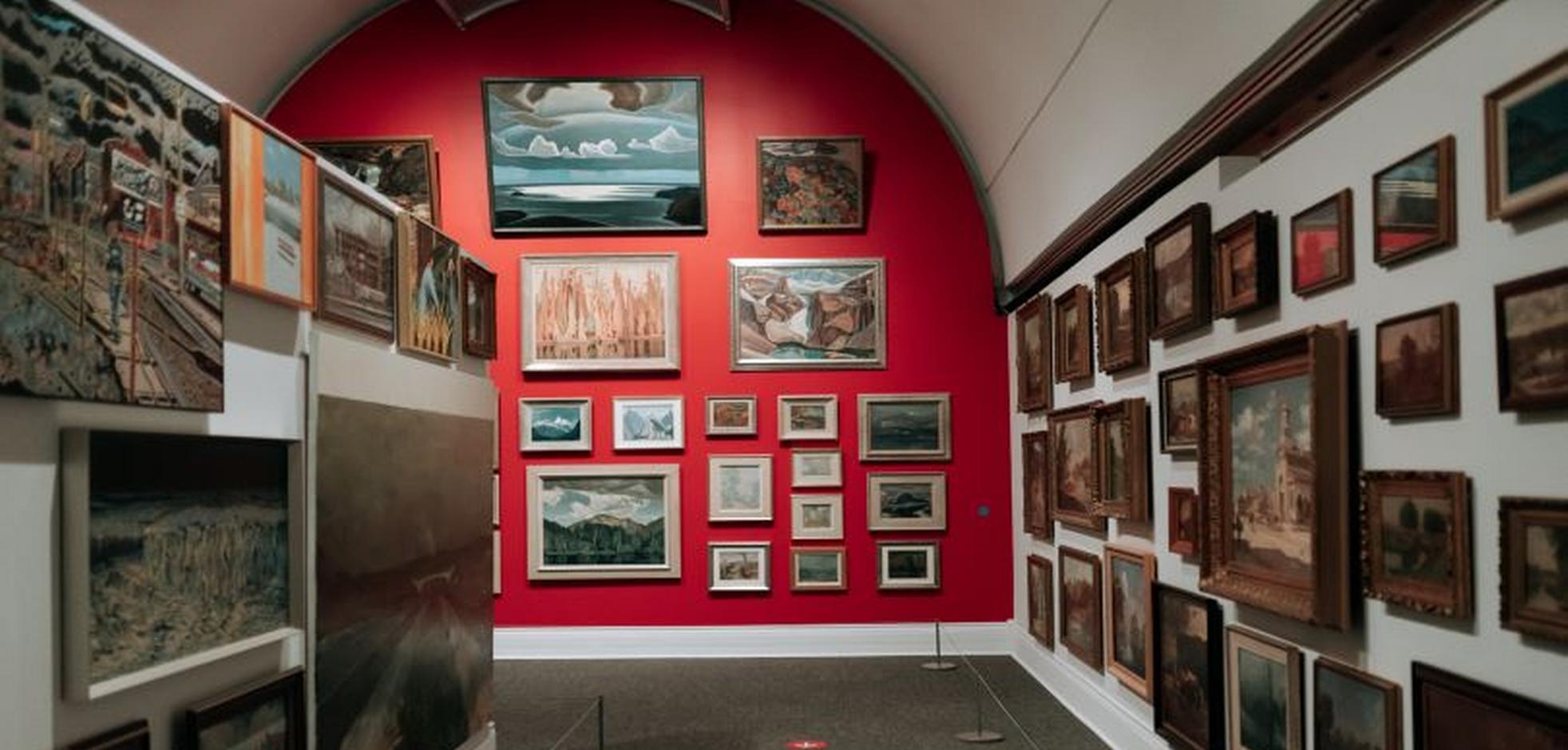 Museum wall with many paintings
