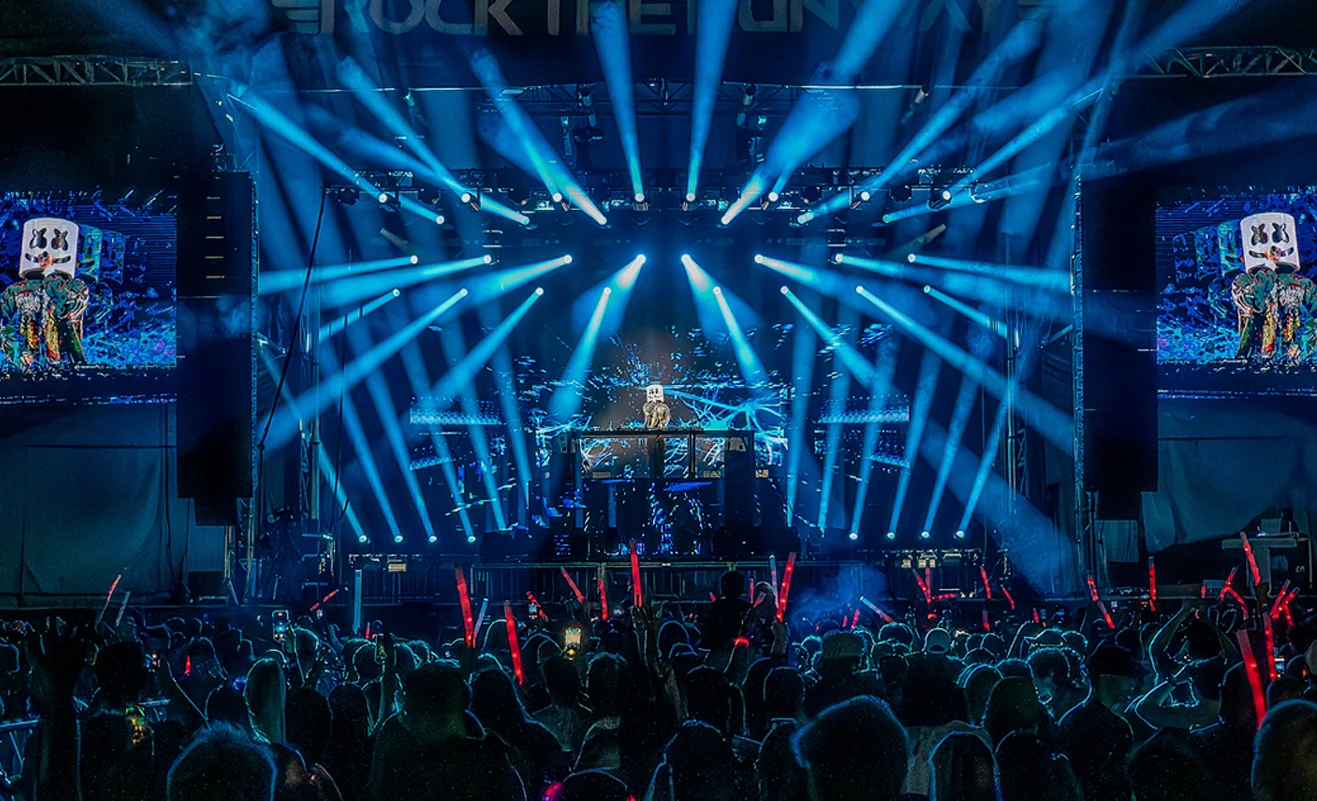 audience watching a live music band on stage with spotlights