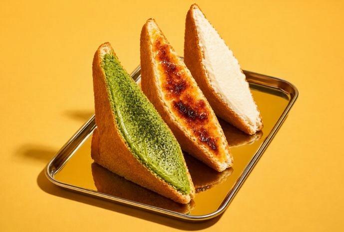 Toasted Egg Cloud sandwich wedges with melted cheese filling served on a tray against a yellow background.