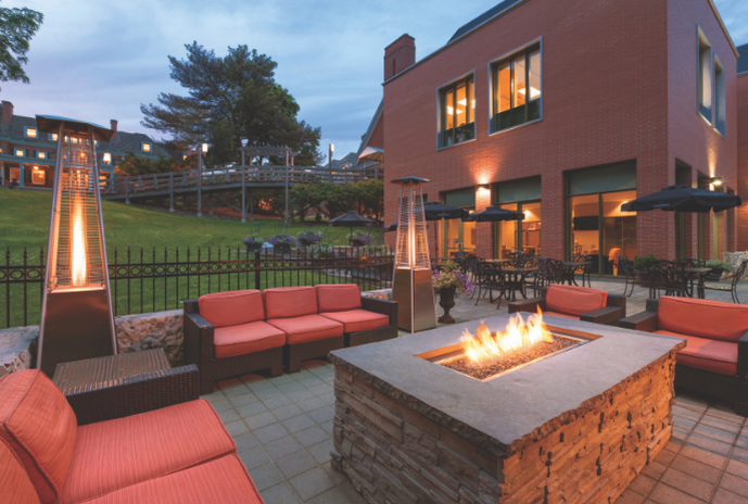 Seating area on outdoor patio with patio heaters in the evening.