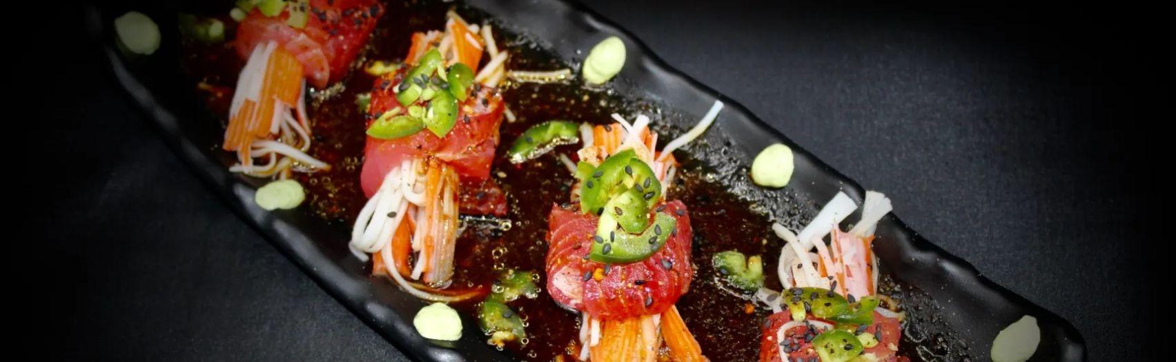 Vibrant layered cocktail with red top yellow base ice and dark rim plus dried citrus slice garnish detail.