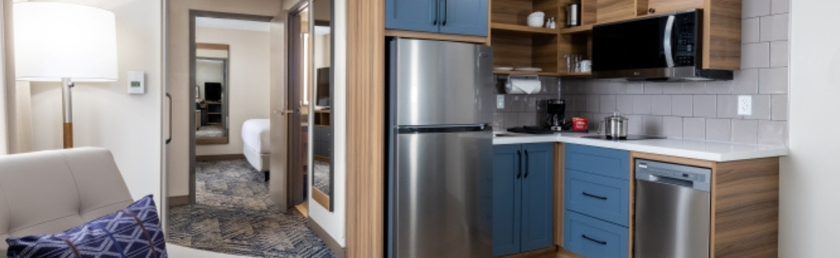 Couch, kitchen area leading to bedroom at Candlewood Suites.