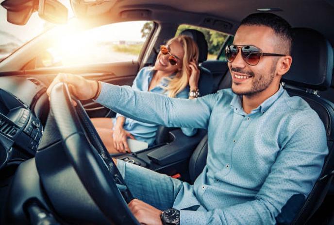 two people sitting in a car smiling