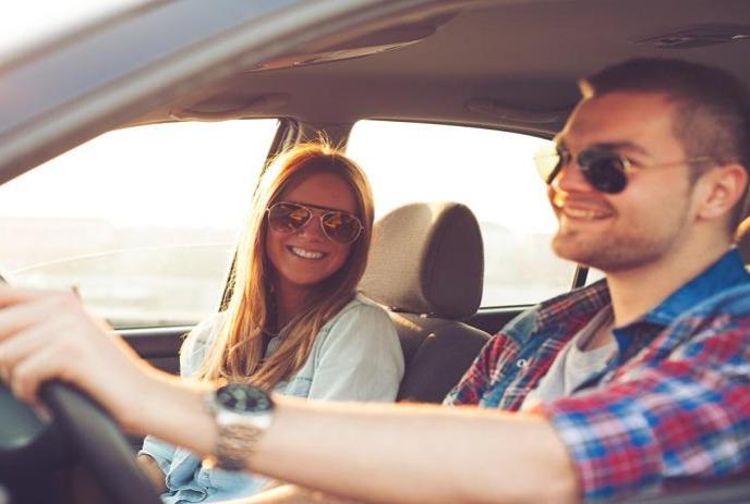 two people sitting in a car smiling