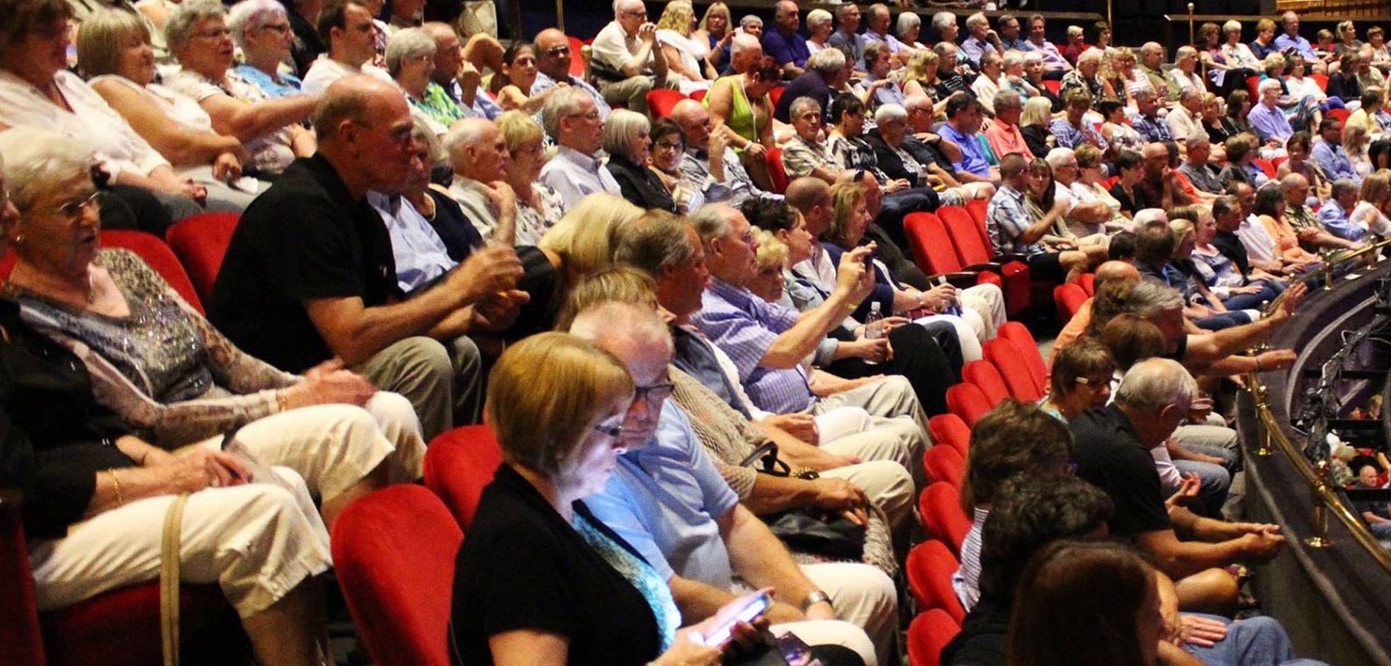 audience sitting in chairs watching stage