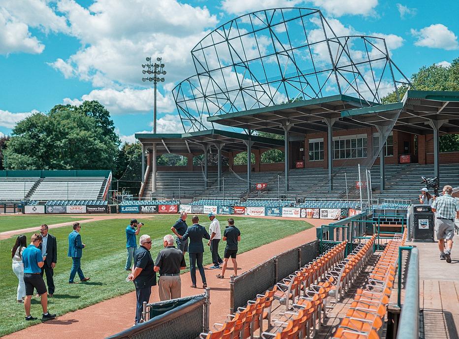 A group of people taking a tour of the baseball grounds of Labatt Park locate din London, Ontario