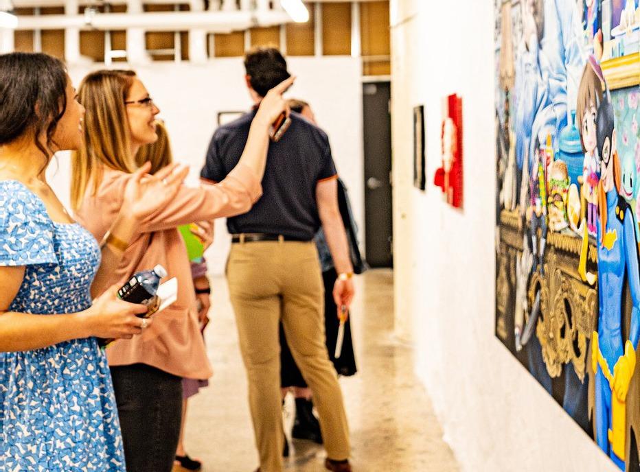 Two females looking at a painting on display at  Art Comp, an exhibition held at 100 Kellogg Lane in London, Ontario