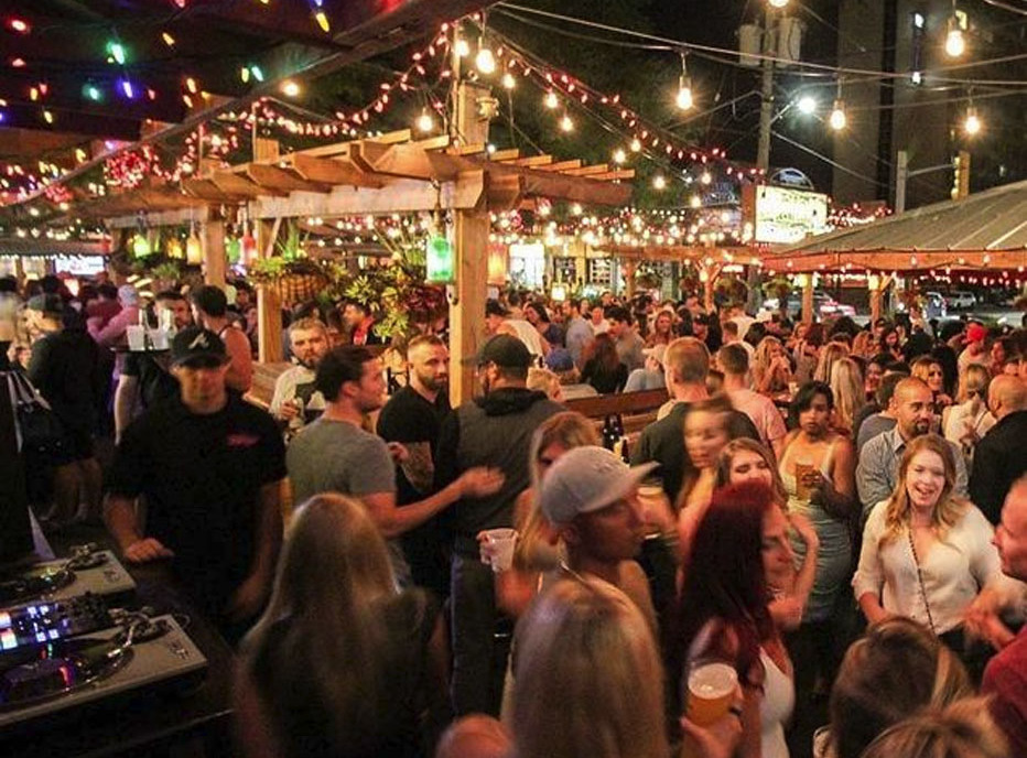 crowd of people socializing at a outdoor patio