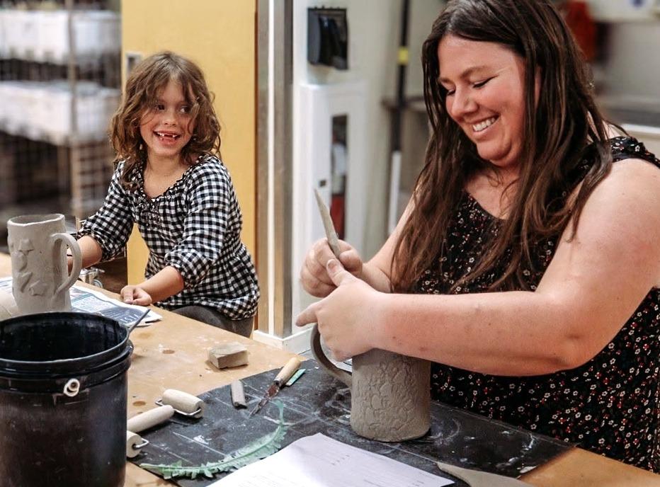 A mother and daughter molding and decorating cups from clay at Clayworx located in London, Ontario