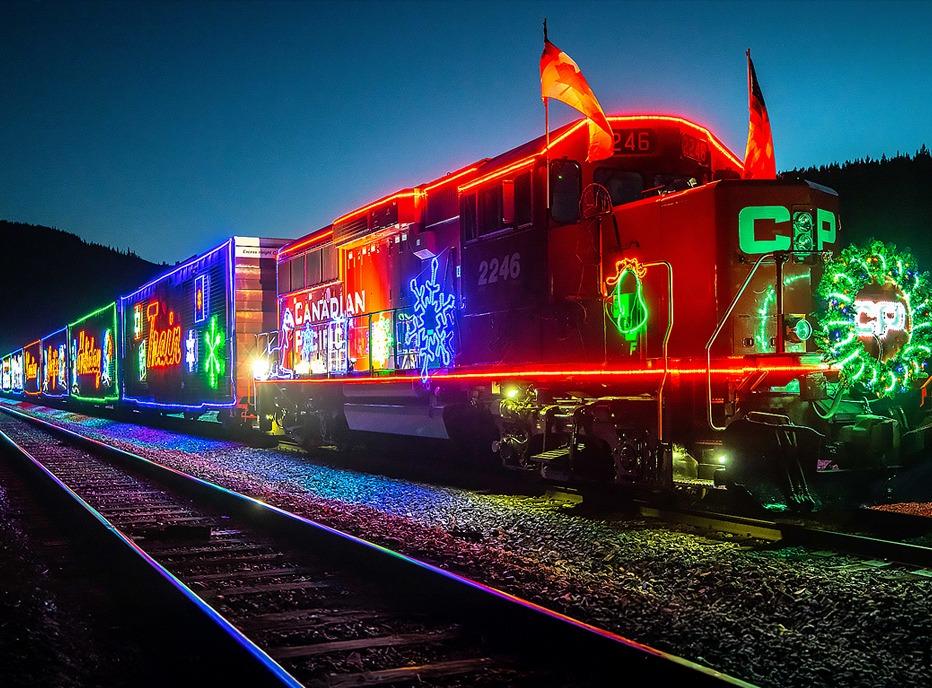 The CPKC Holiday Train decorated with neon lights at night
